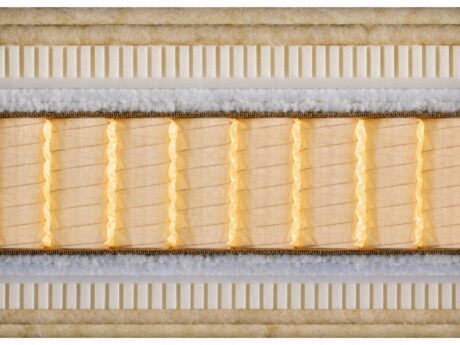 Close-up cross-section of Schramm Mythos handmade mattress showing natural material layers including horsehair, cotton wadding, jute border, and a traditional spring core, handmade in Germany