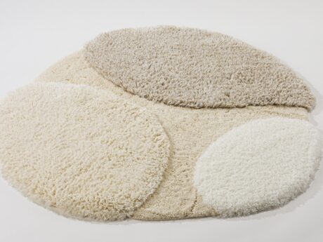 Soft round shaggy pet bed in cream tones with overlapping circular cushions.