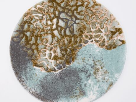 Round Abyss & Habidecor bath mat with abstract branching pattern in teal, brown, and beige on a white background.