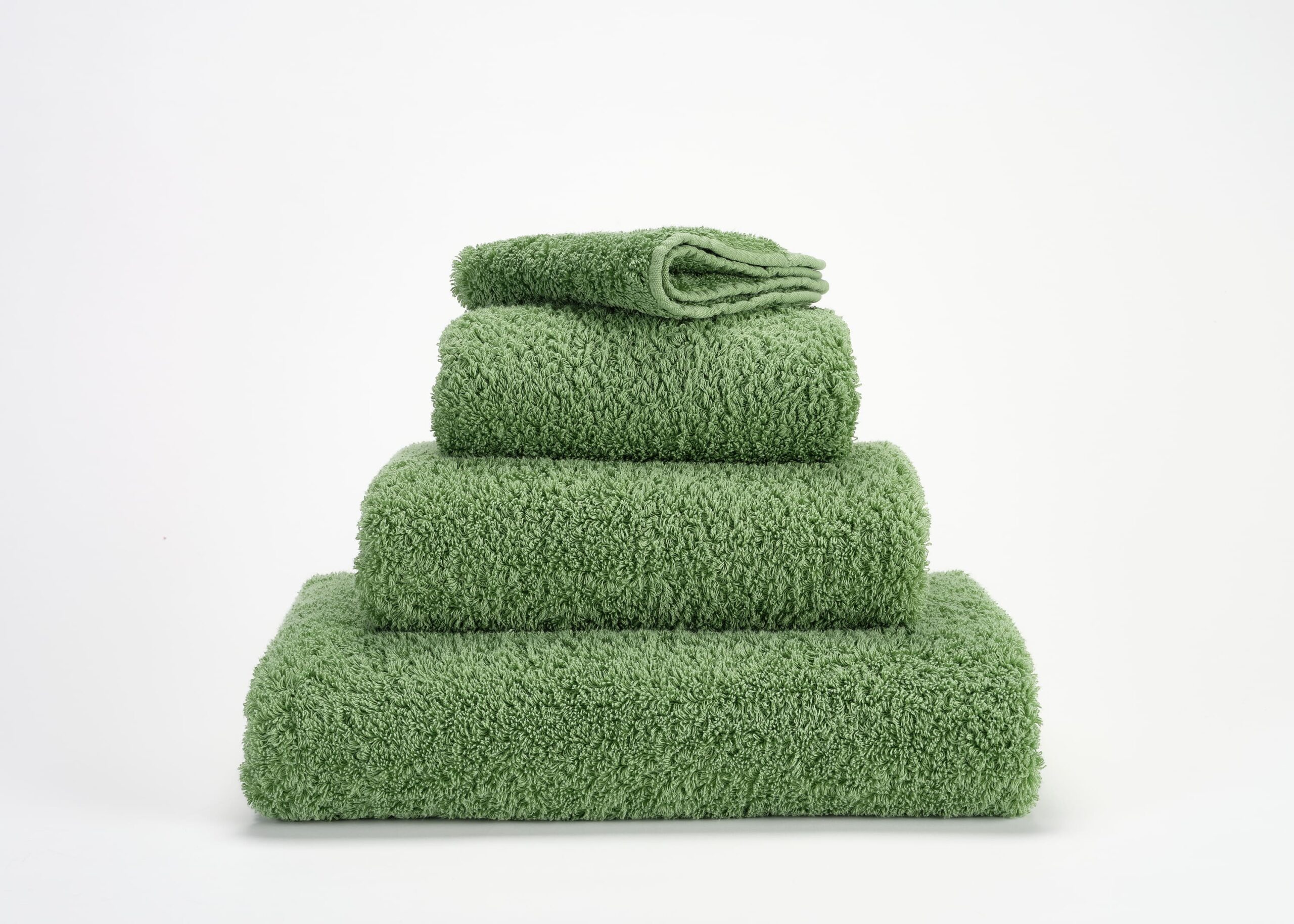 Abyss & Habidecor Super Pile luxury cotton towel set in fresh green stacked on white background
