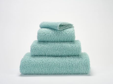 Abyss & Habidecor Super Pile luxury cotton towel set in aqua green stacked on white background
