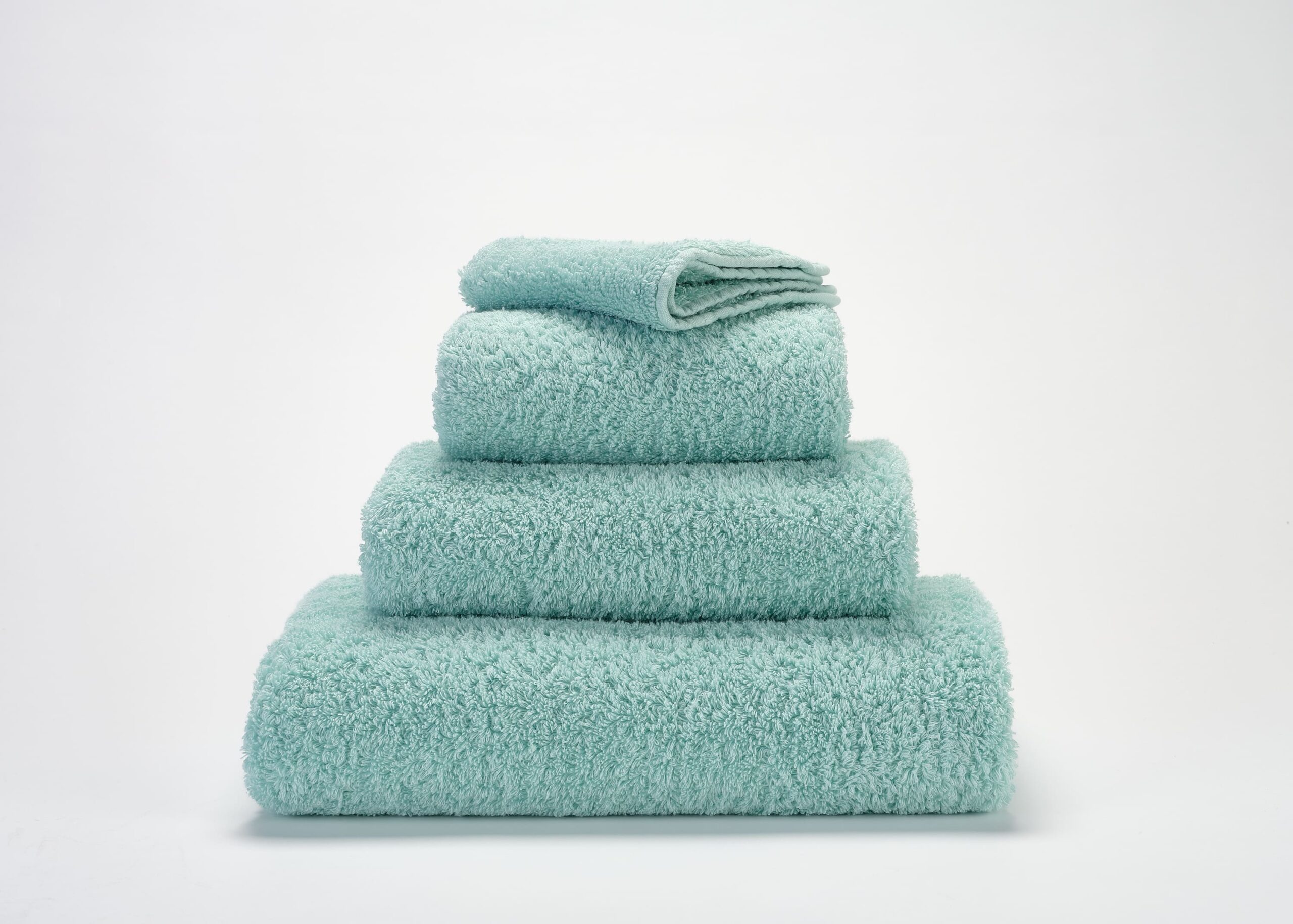 Abyss & Habidecor Super Pile luxury cotton towel set in aqua green stacked on white background