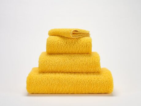 Abyss & Habidecor Super Pile 830 luxury cotton towels in golden yellow stacked