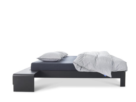 Auping Auronde platform bed side view with dark frame and white bedding
