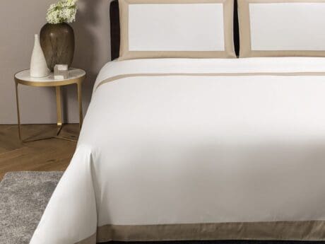 Frette Bold bed linen set with beige border on a double bed