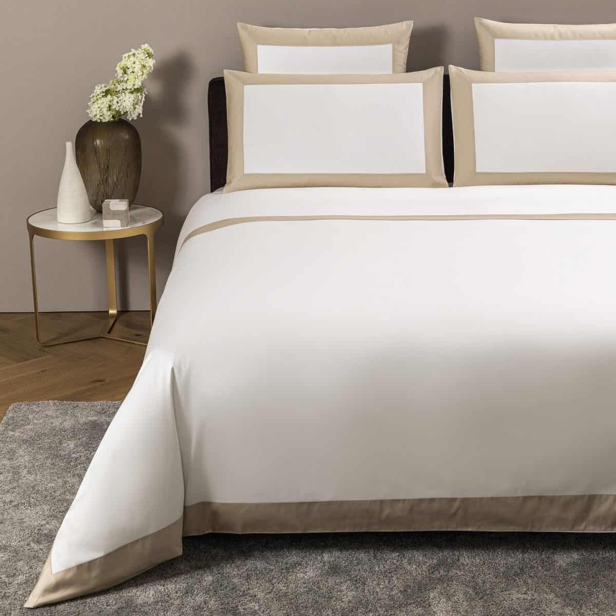 Frette Bold bed linen set with beige border on a double bed